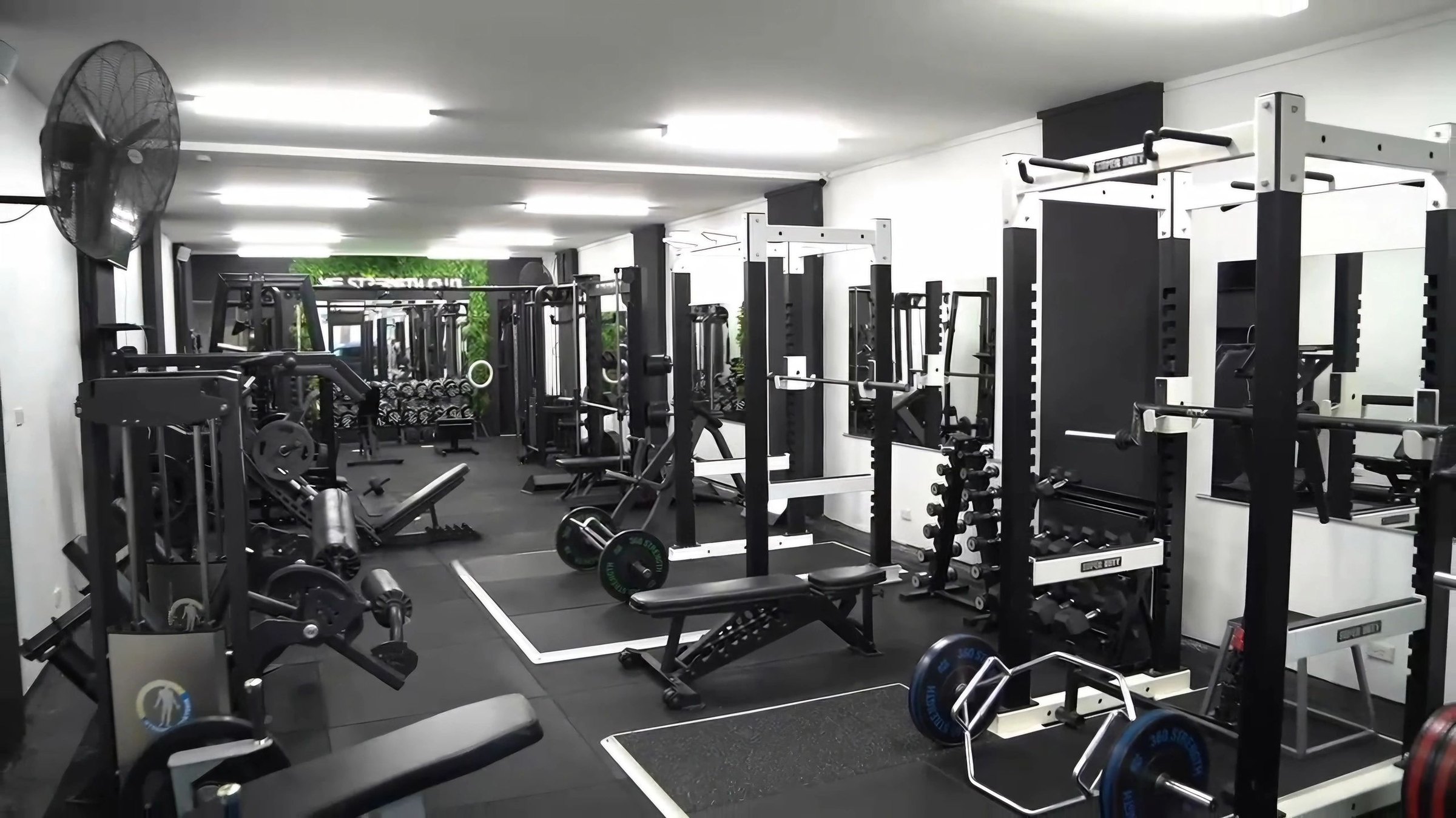 The M|E Strength Club training floor with racks and plates